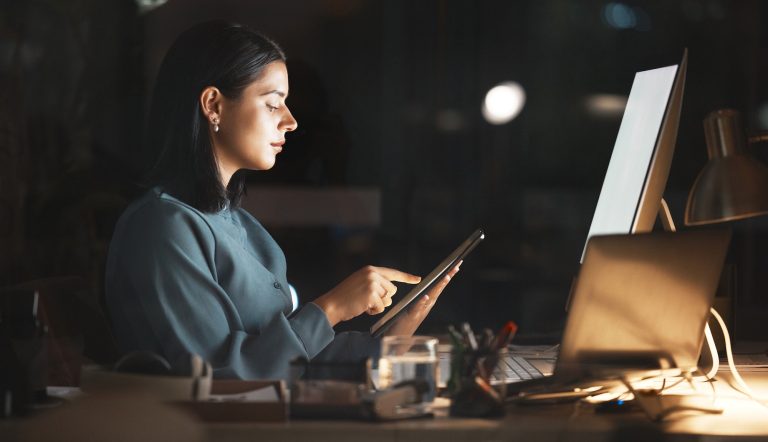 Woman working on tablet in office.