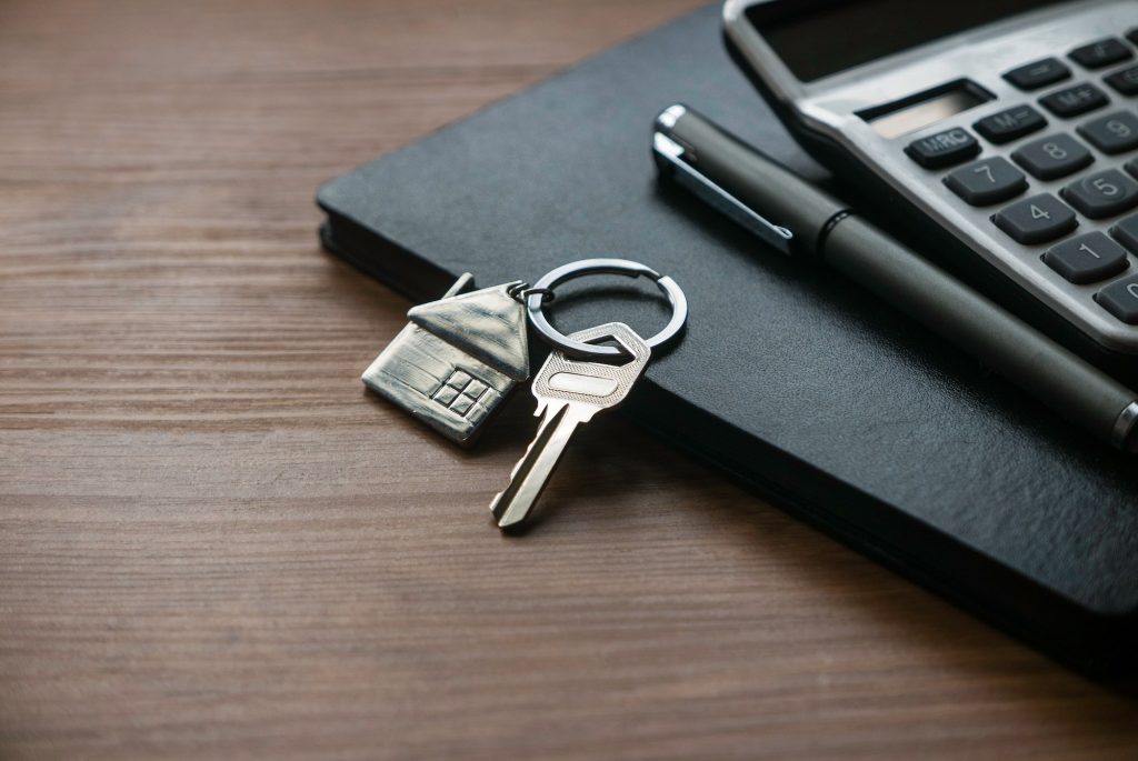House key on notebook with calculator