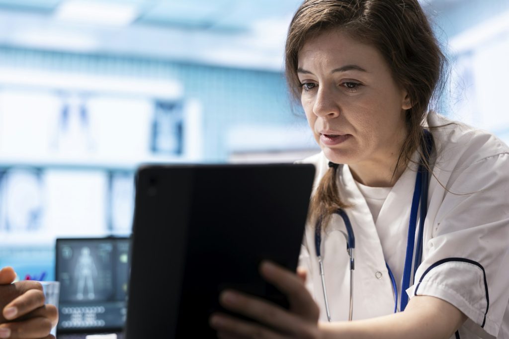 Clinician reviewing information on a tablet in a hospital setting